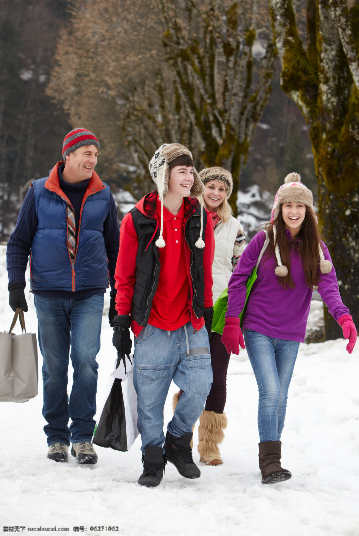 雪地 上 行走 一家人 外国一家 微笑 手提袋 树 野外 生活人物 人物图片