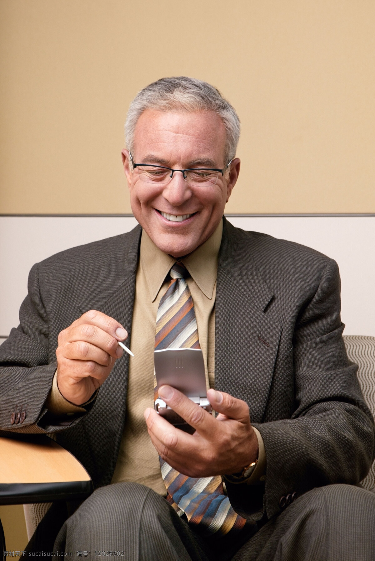 看着 手机 微笑 男人 商务 商业 商务人士 商业精英 白领 职业 商务素材 国外人物 坐着 商务男性 人物图片